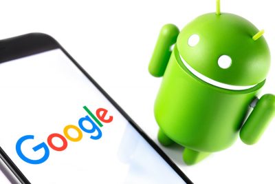 closeup Google Android figure and smartphone with Google logo. Google Android is the operating system for smartphones, tablet computers and other devices. Moscow, Russia – March 17, 2019